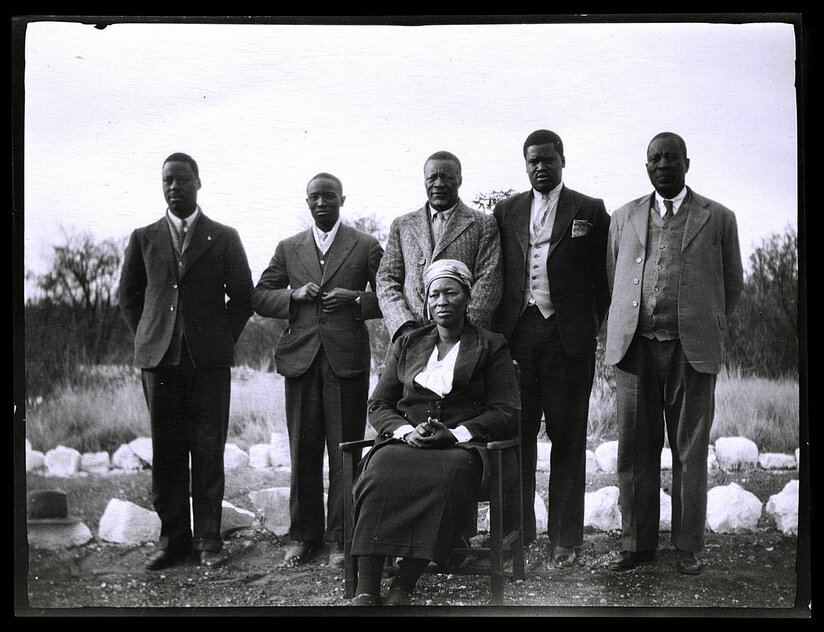 Semane Khama (seated), Tshekedi Khama (standing, background), and councillors (all standing).